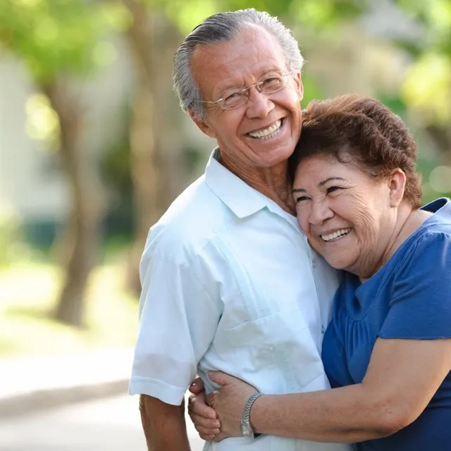 Smiling older couple hugging outdoors